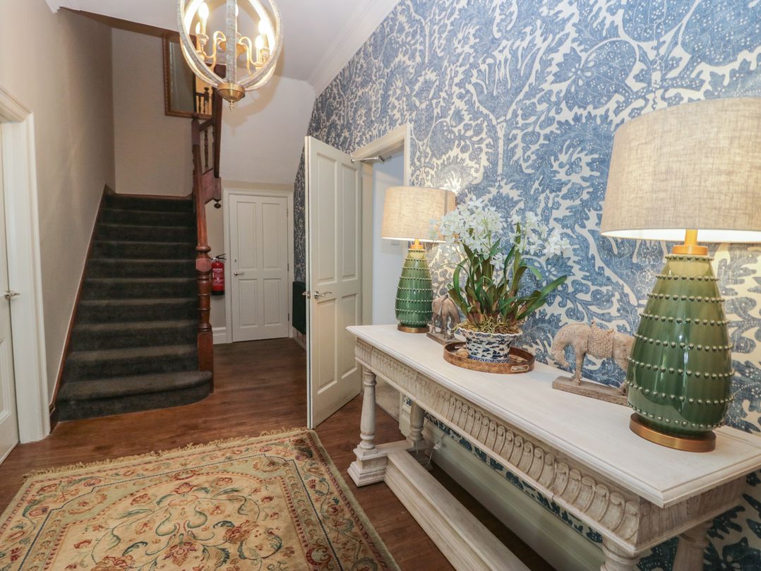 A hallway with a staircase and console table at The Boundary in Windermere