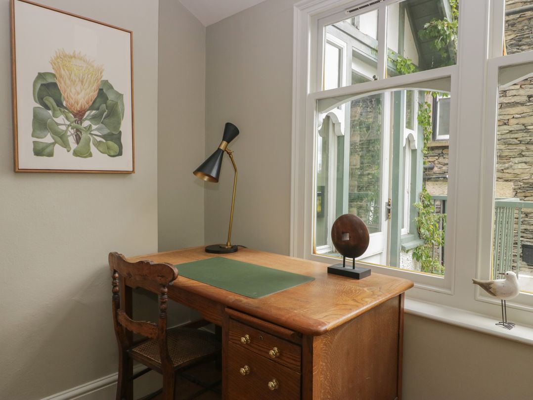 An office with a wooden desk and lamp at The Boundary in Windermere