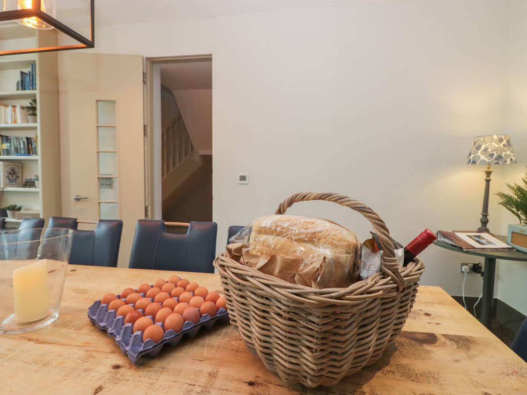 A dining room with a table set and a basket containing bread and eggs at The Boundary in Windermere