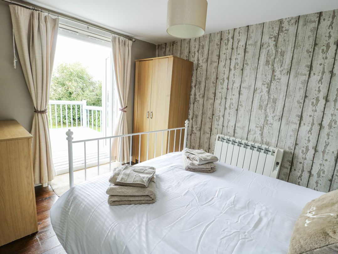 A bedroom with a bed and wardrobe at Harbour Lights in Holyhead