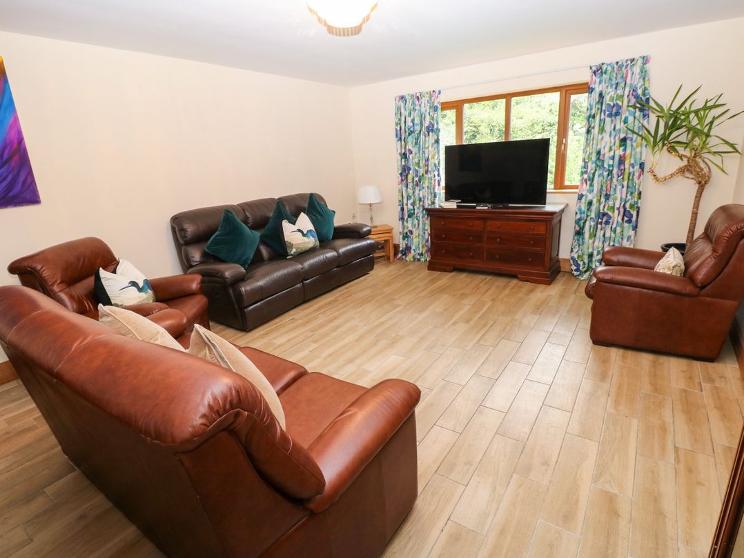 A living room with sofas and a television at Ty-Gan Dderwen in Llangennech, Llanelli