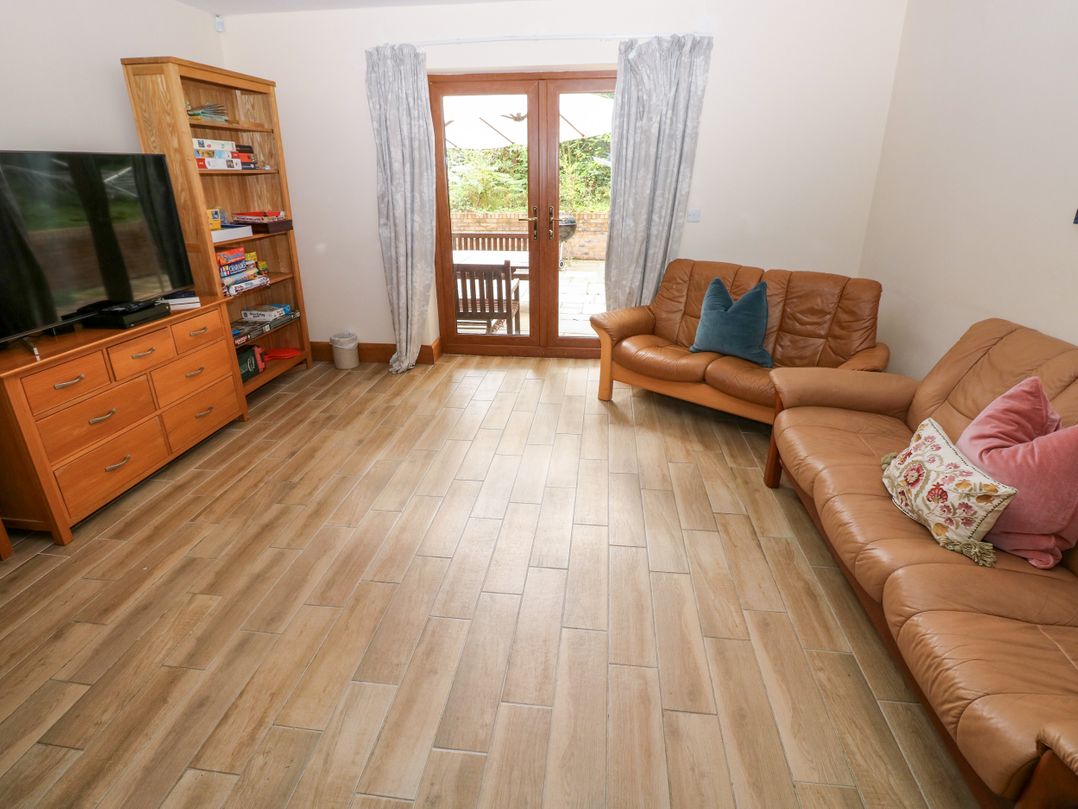 A living room with a television and shelves at Ty-Gan Dderwen in Llangennech, Llanelli