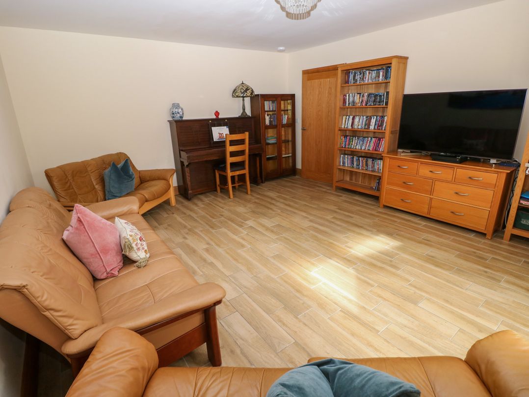 A living room with a sofa and television at Ty-Gan Dderwen in Llangennech, Llanelli