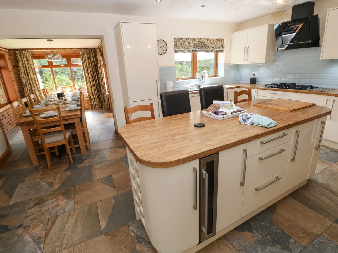 A kitchen with an island and dining area at Ty-Gan Dderwen in Llangennech, Llanelli
