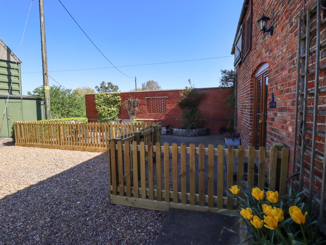A garden area with a fence and plants at Barn Owl near Louth