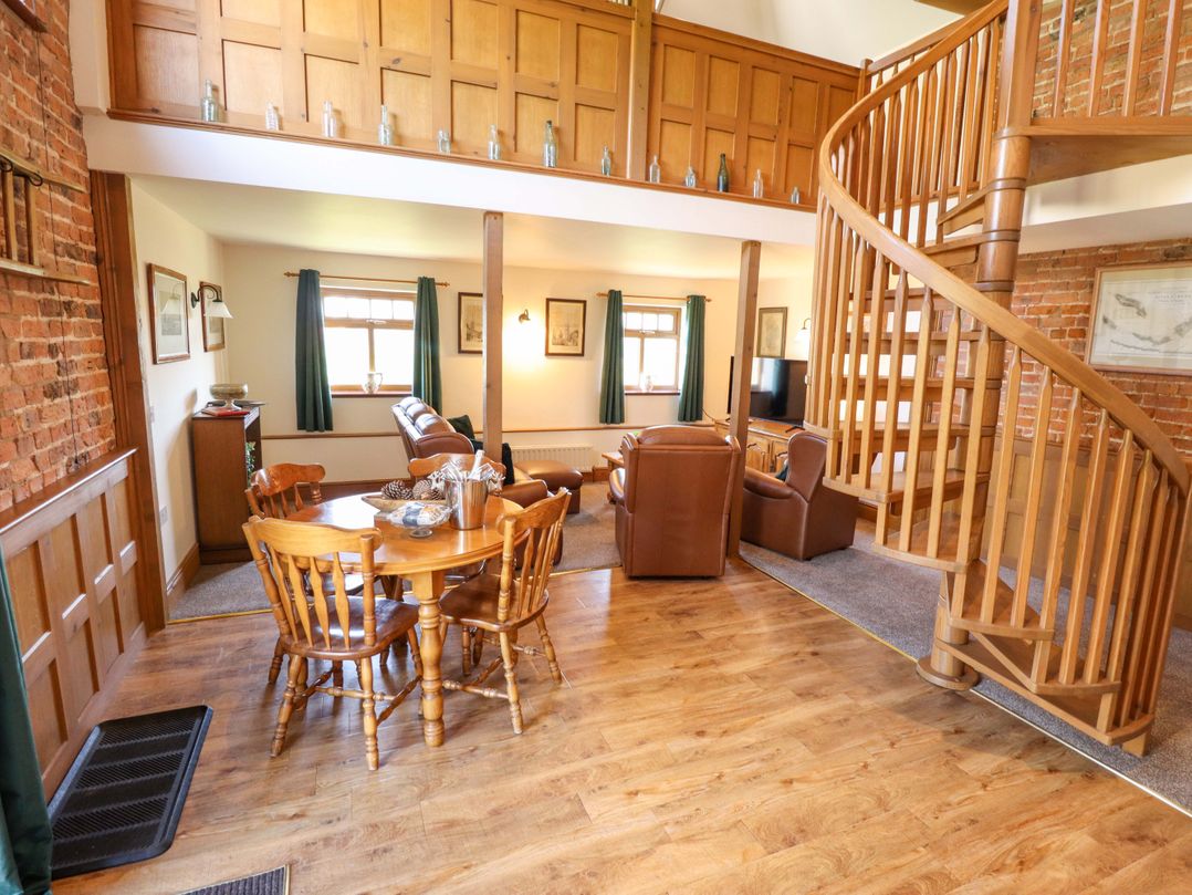 A living room with a sofa and dining area at Barn Owl near Louth