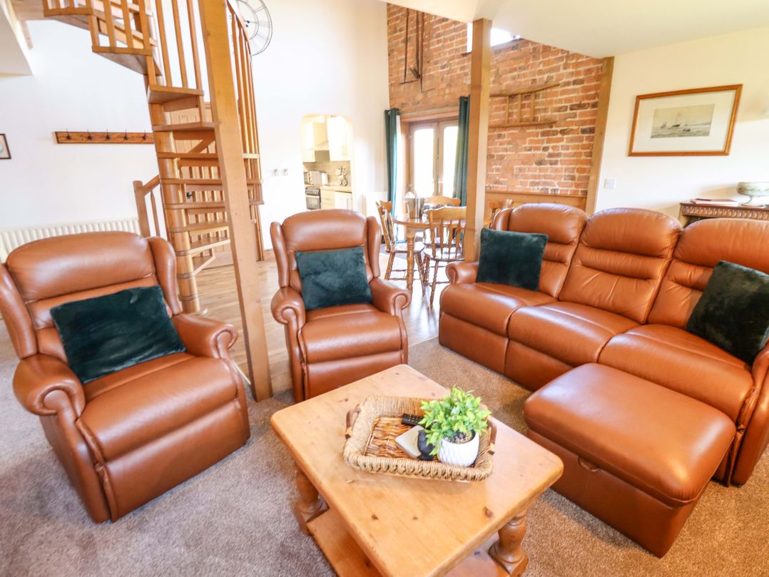 A living room with seating and dining area at Barn Owl near Louth