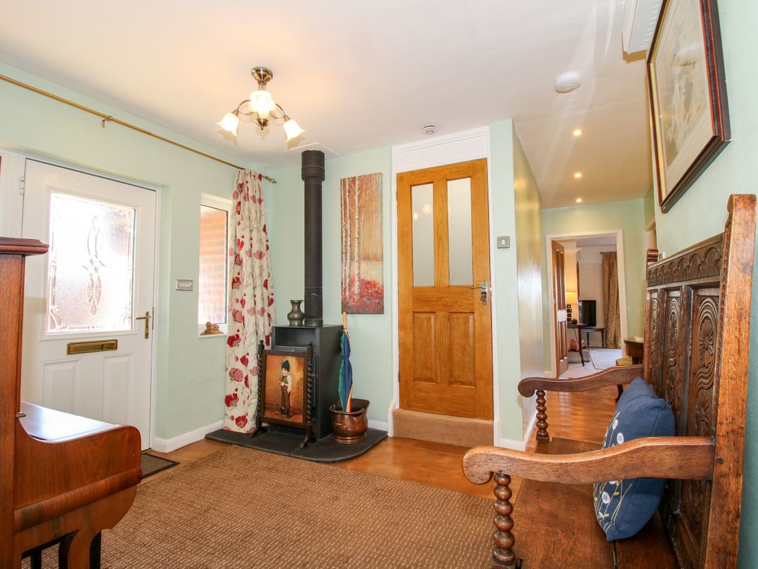 A hallway with a wooden bench and a stove at The Rumbles in Ludlow