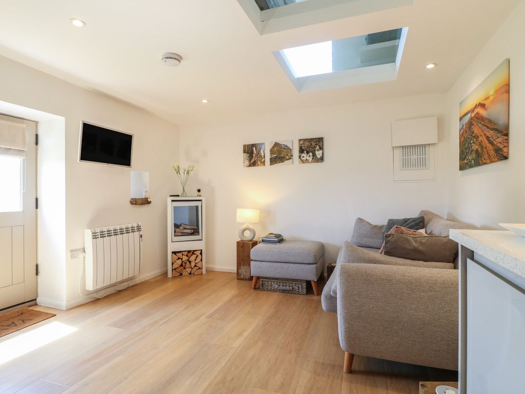 A living room with a sofa and television at Little Barn in Grindon