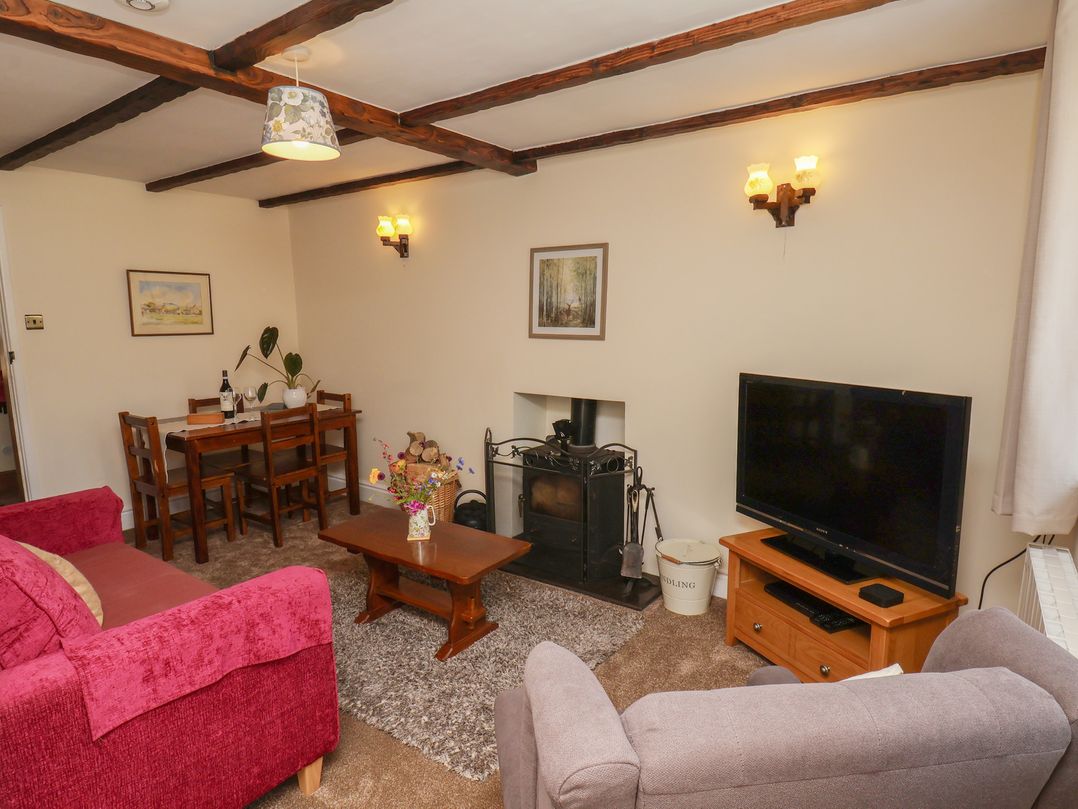 A living room with a sofa and dining table at 4 Lilac Cottages Ainthorpe