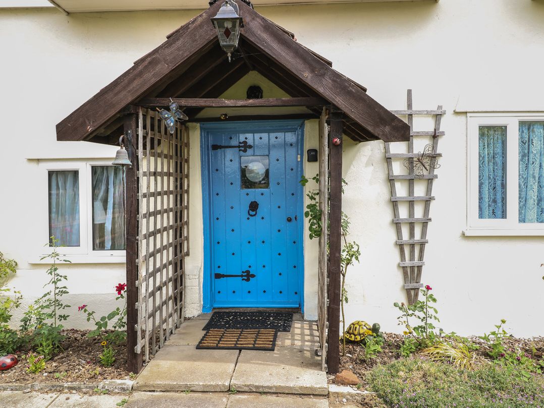 A blue door with a trellis next to it at Driftway Stables Retreat in Diss