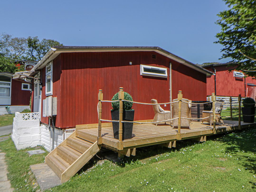A deck with chairs and a planter at Chalet 23 Erw Porthor Tywyn