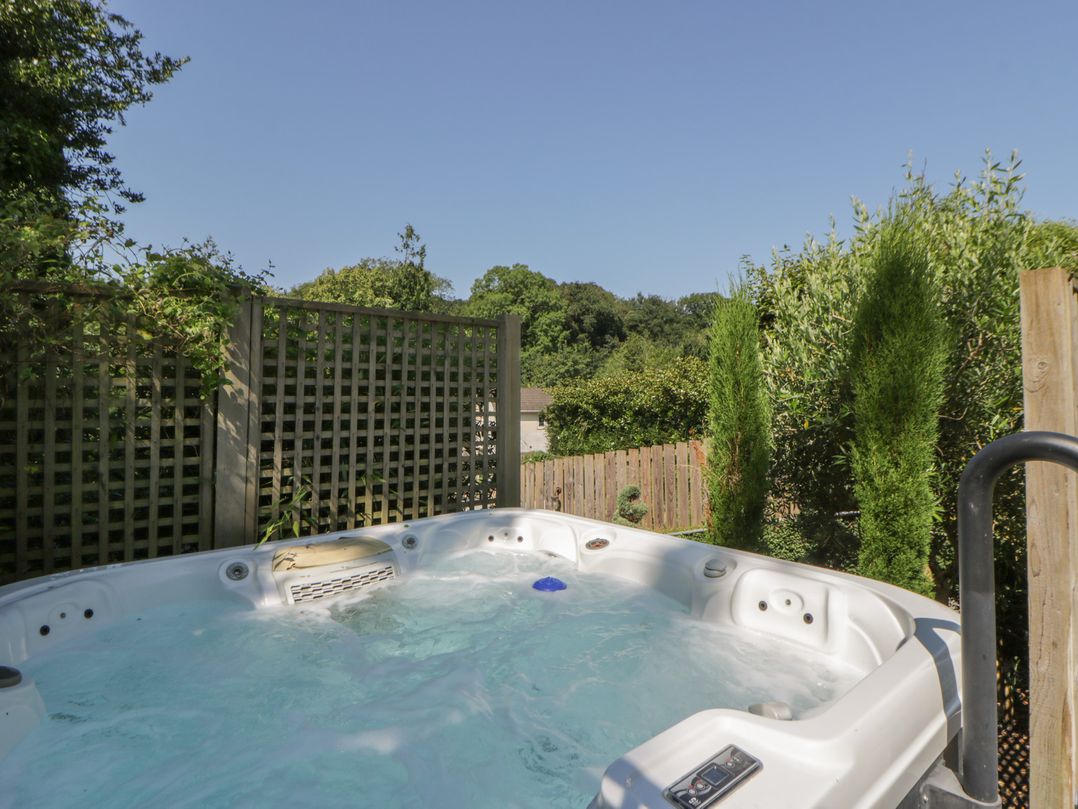 A hot tub surrounded by greenery at The Old Vicarage in Laugharne