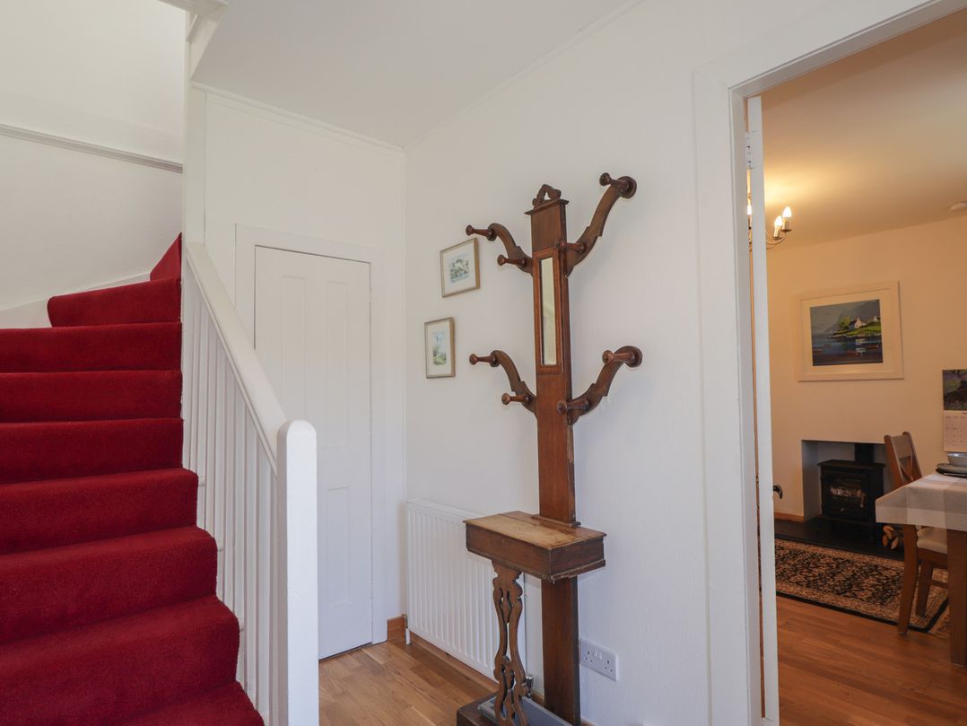 A hallway with stairs and a coat rack at Tigh a Phailean Letterfearn