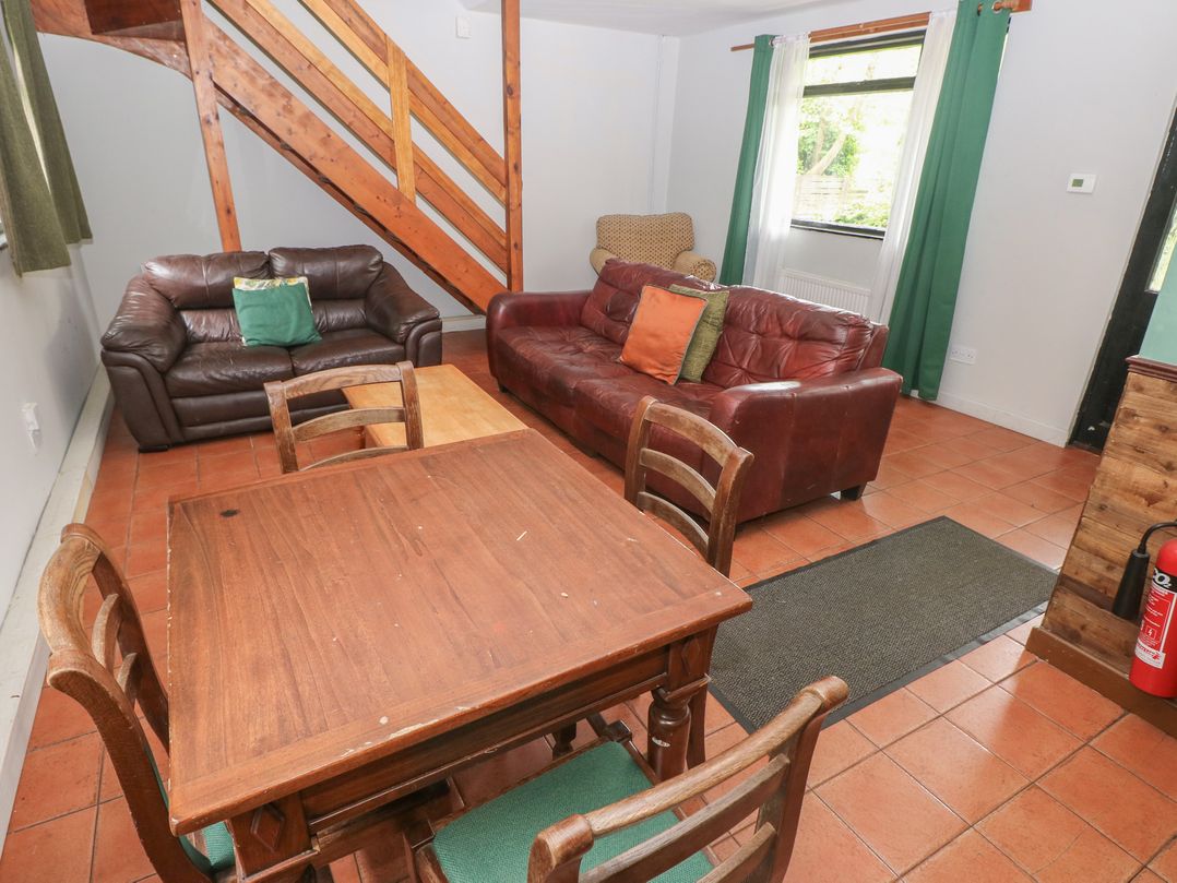 A living room with a sofa and dining table at Cabin No. 9 - Salt and Fern Cabins in Goytre near Port Talbot