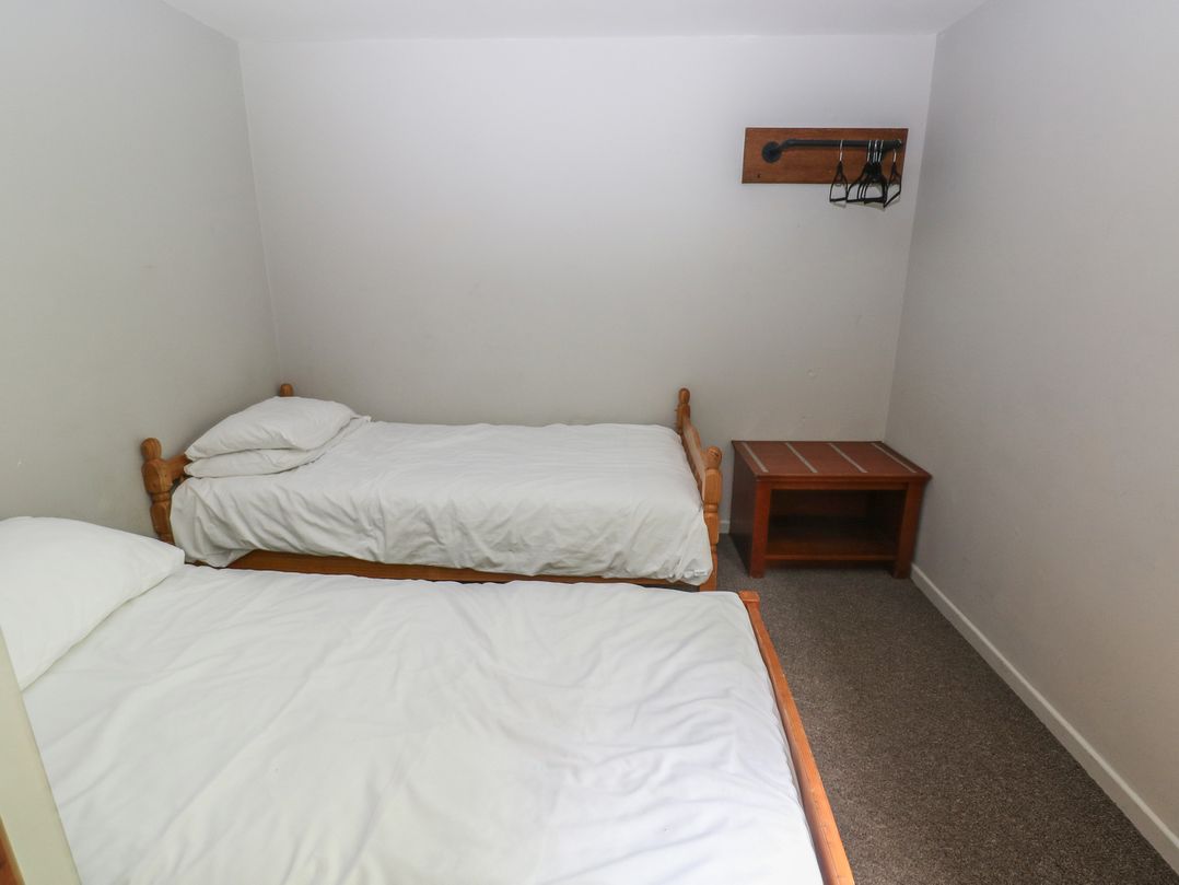 A bedroom with two beds and a table at Cabin No. 9 - Salt and Fern Cabins Goytre near Port Talbot