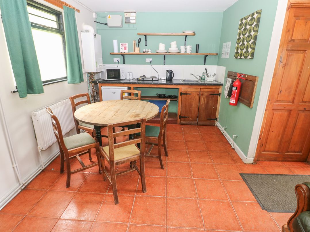 A kitchen with a table and chairs at Cabin No. 12 - Salt and Fern Cabins Goytre near Port Talbot
