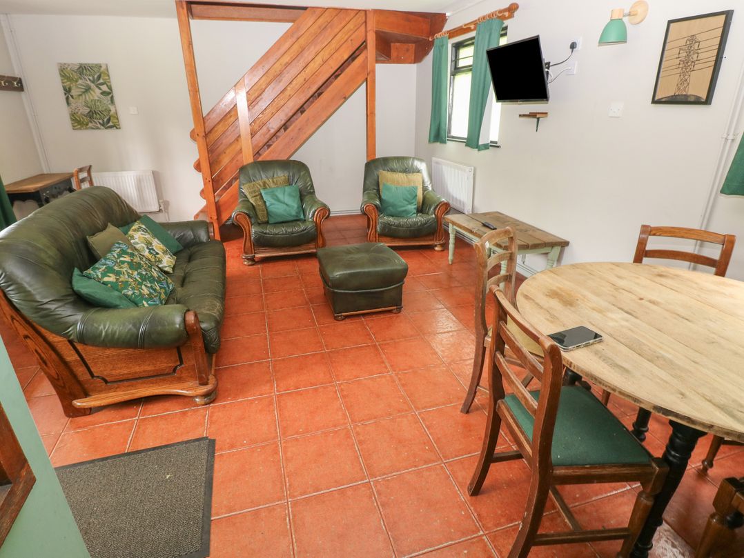 A living room with a sofa, armchairs, and a dining table at Cabin No. 12 - Salt and Fern Cabins in Goytre near Port Talbot