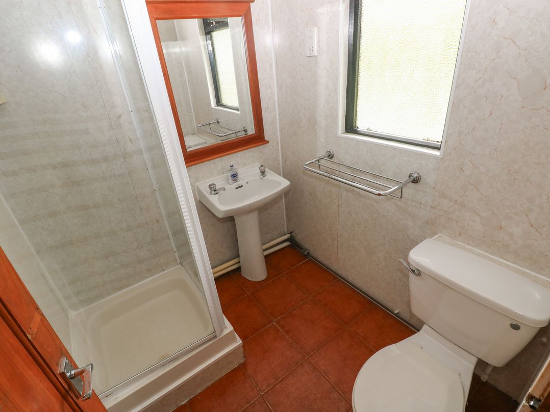 A bathroom with a shower, sink, and toilet at Cabin No. 12 - Salt and Fern Cabins in Goytre near Port Talbot