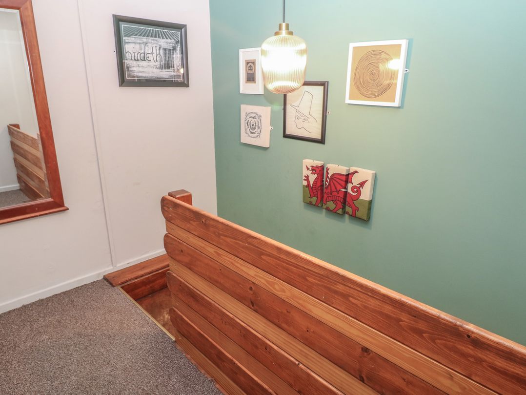 A hallway with wooden wall and various wall art at Cabin No. 12 - Salt and Fern Cabins Goytre near Port Talbot