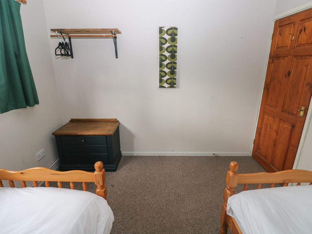 A bedroom with two beds and a storage chest at Cabin No. 12 - Salt and Fern Cabins Goytre near Port Talbot