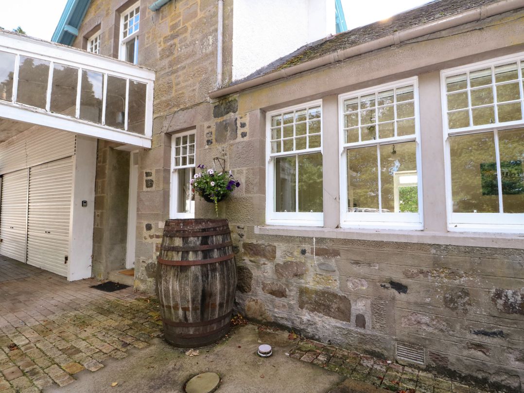 An outdoor area with a barrel and flowers at West House in Stanley