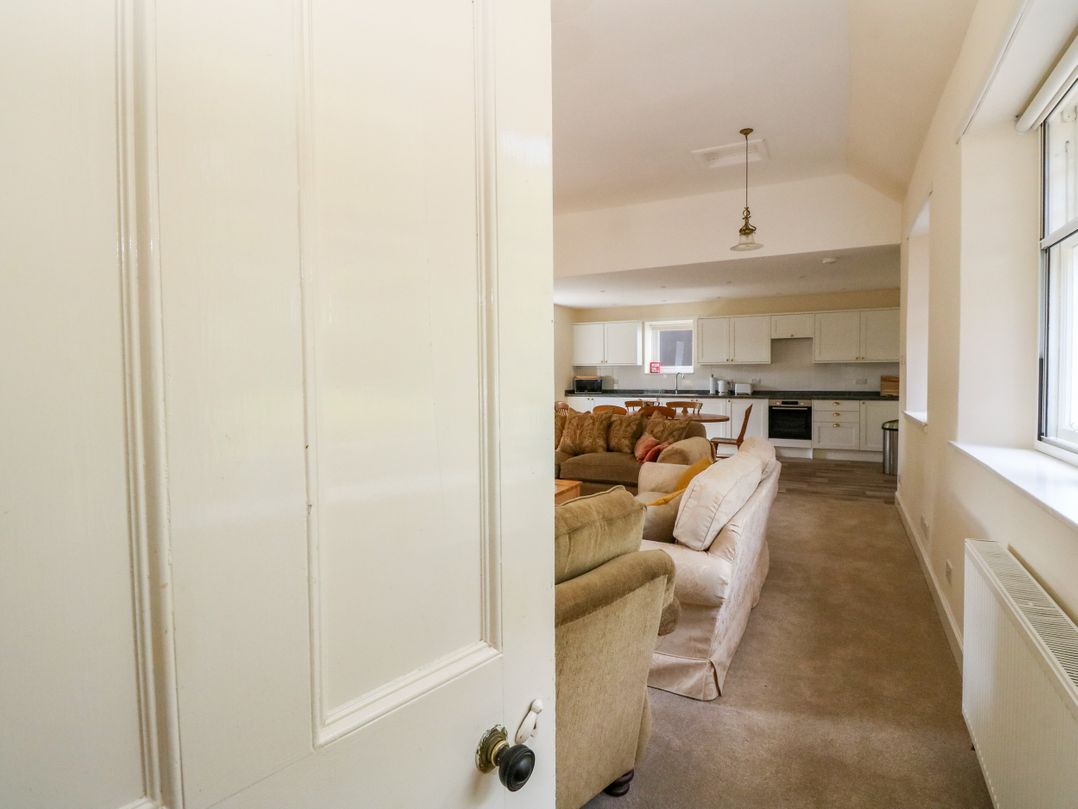 A living room with a door leading to a kitchen at West House in Stanley