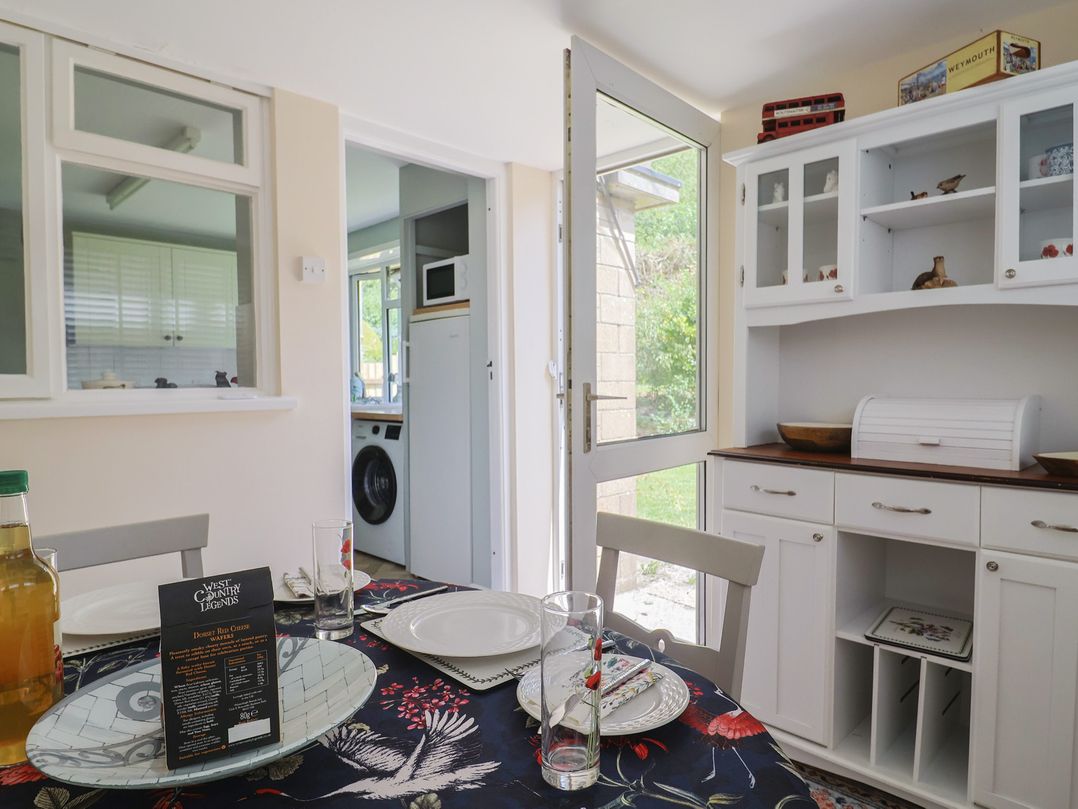 A dining room with a table and chairs at Tane in Winterborne Stickland