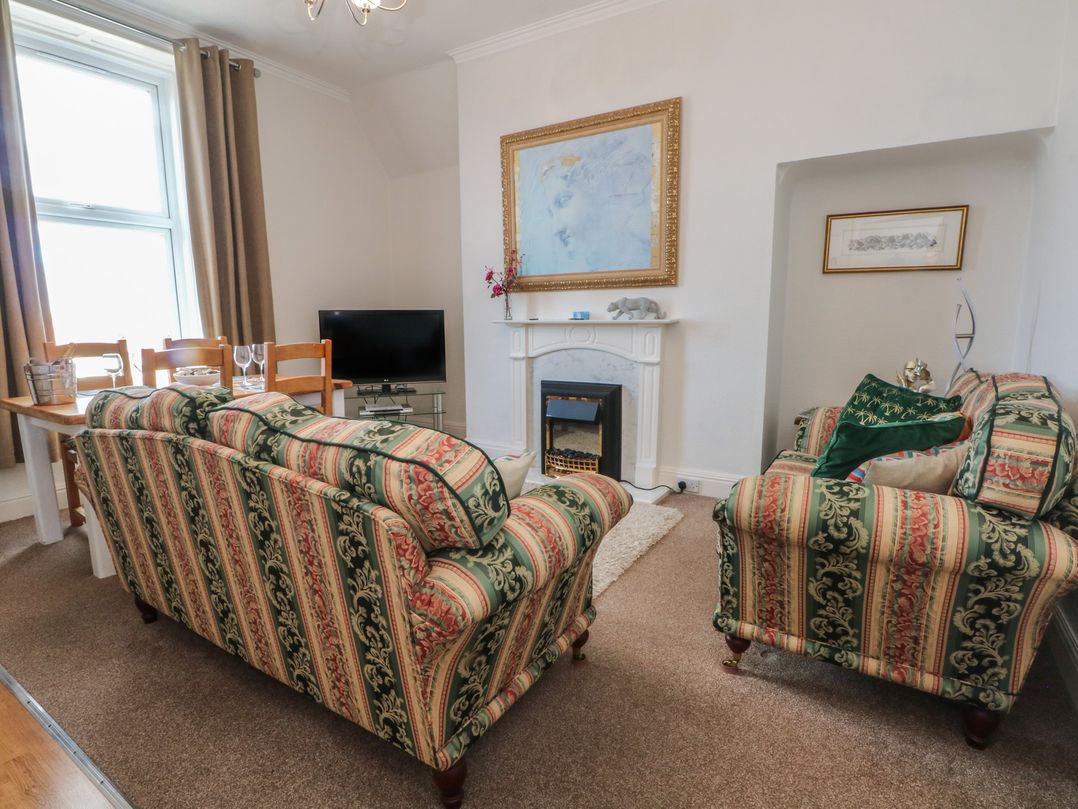 A living room with a sofa, table, and television at Apartment 3 in Lytham St. Annes