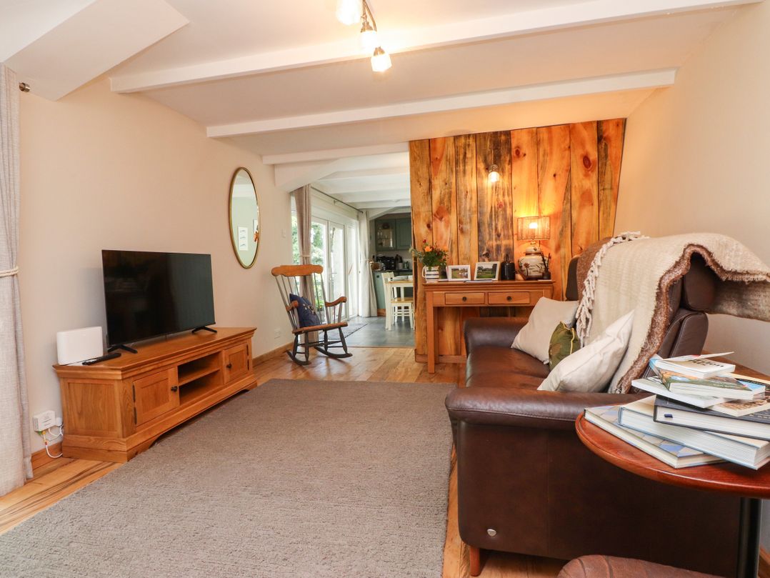 A living room with a television and sofa at Woodman's Lodge in Llanallgo near Moelfre