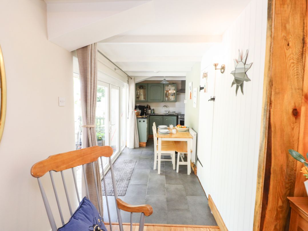 A dining room with a table and chairs at Woodman's Lodge Llanallgo near Moelfre
