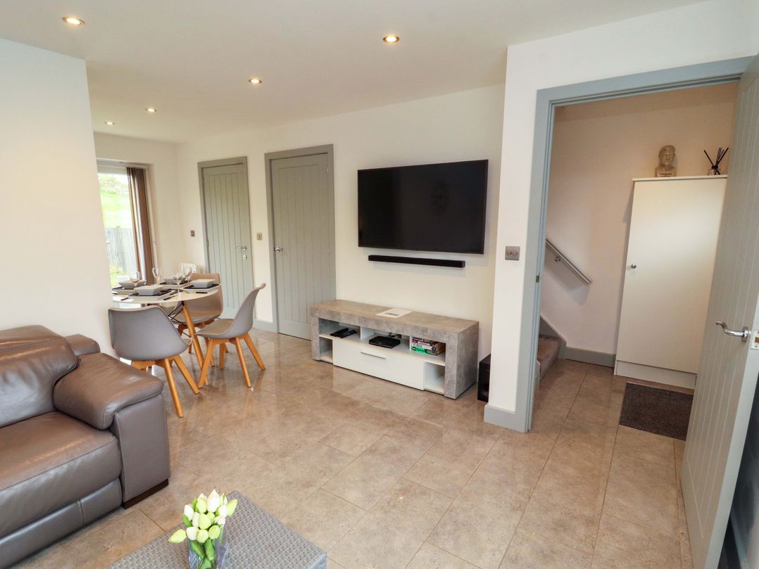 A living room with a sofa and dining table at 11 The Forge in Brampton