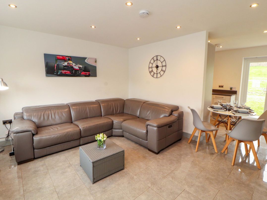 A living room with a sofa and dining area at 11 The Forge in Brampton