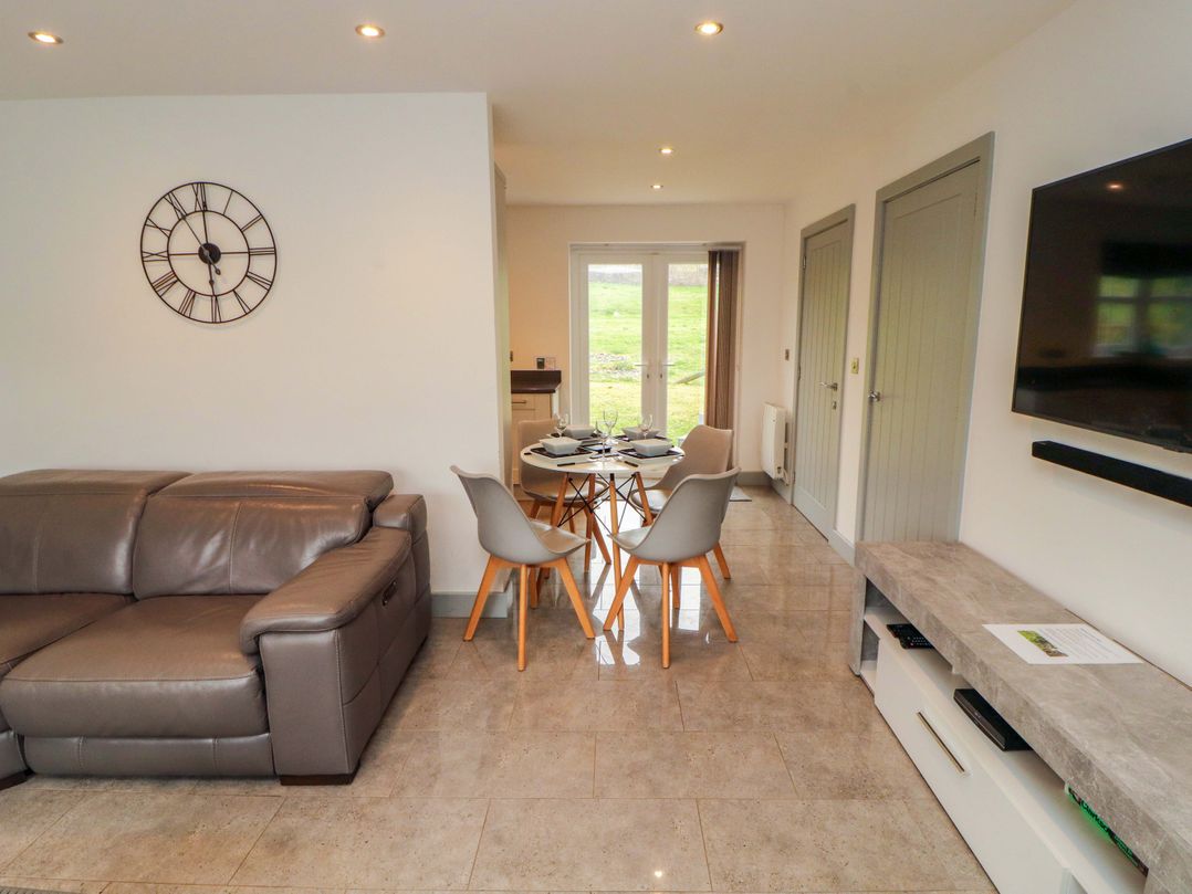 A living room with a sofa and dining area at 11 The Forge in Brampton
