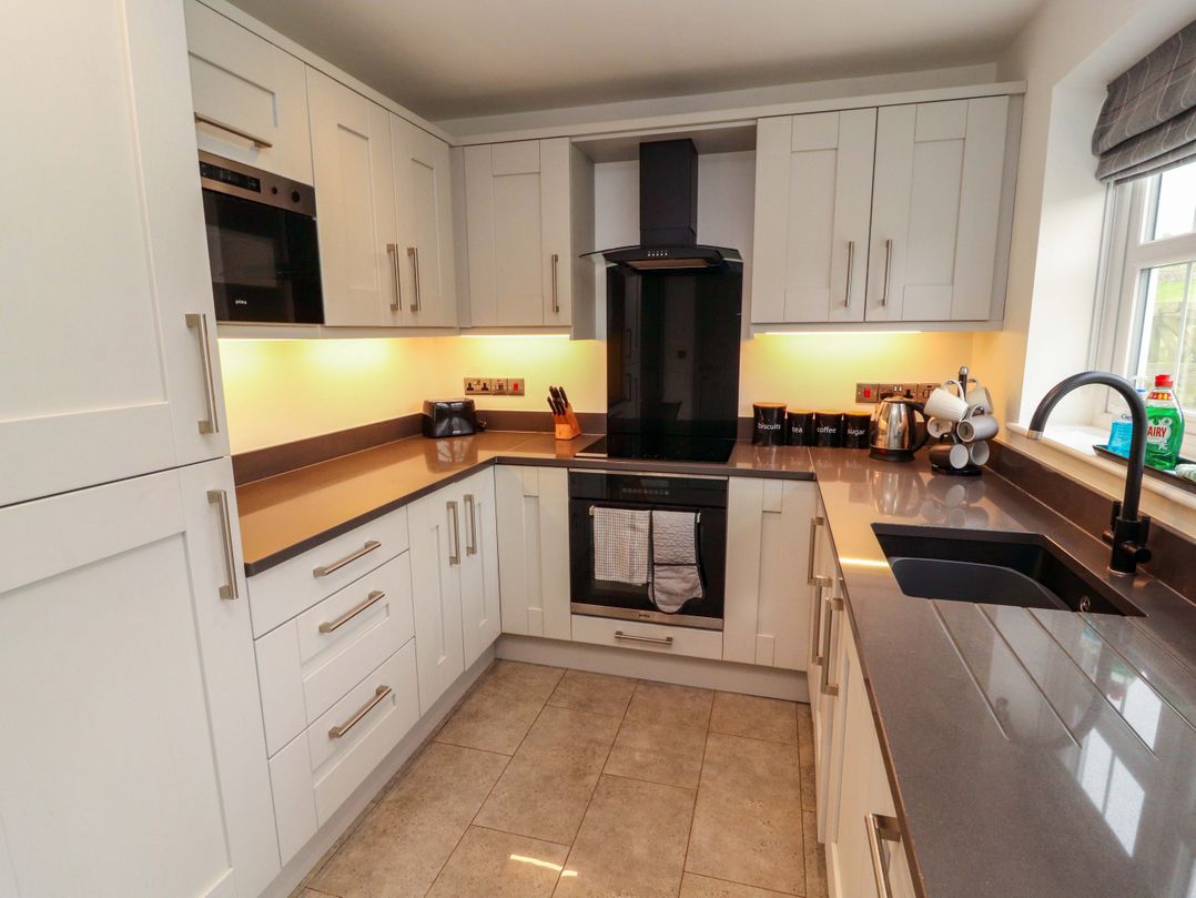 A kitchen with cabinets, oven, sink, and appliances at 11 The Forge Brampton