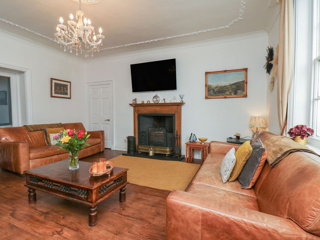 A living room with a fireplace and two sofas at Reighton House Reighton near Filey