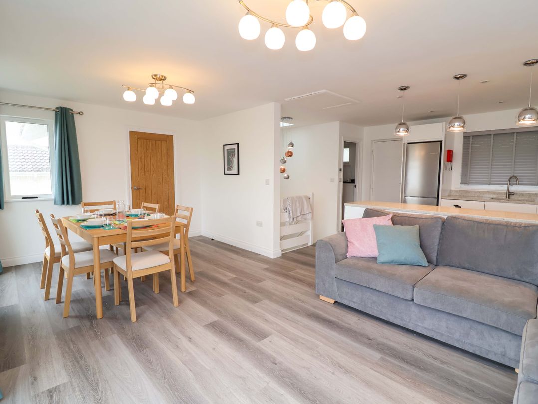 A dining room with a table and chairs and a sofa at Belvedere in Woolacombe