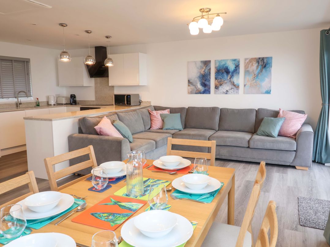 A dining room with a table set and a sofa at Belvedere in Woolacombe