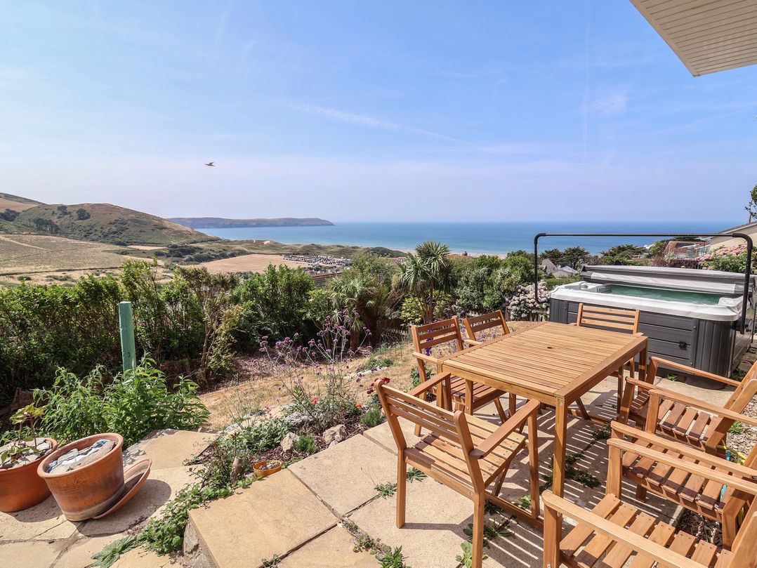 A garden with a table and chairs overlooking the sea at Belvedere in Woolacombe