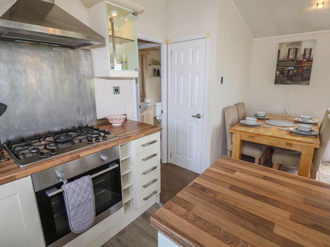 A kitchen with a stove and dining table at Plot 34 near Armathwaite
