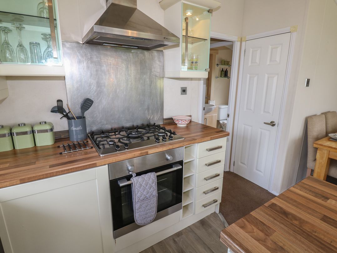 A kitchen with a gas stove and wooden countertops at Plot 34 near Armathwaite