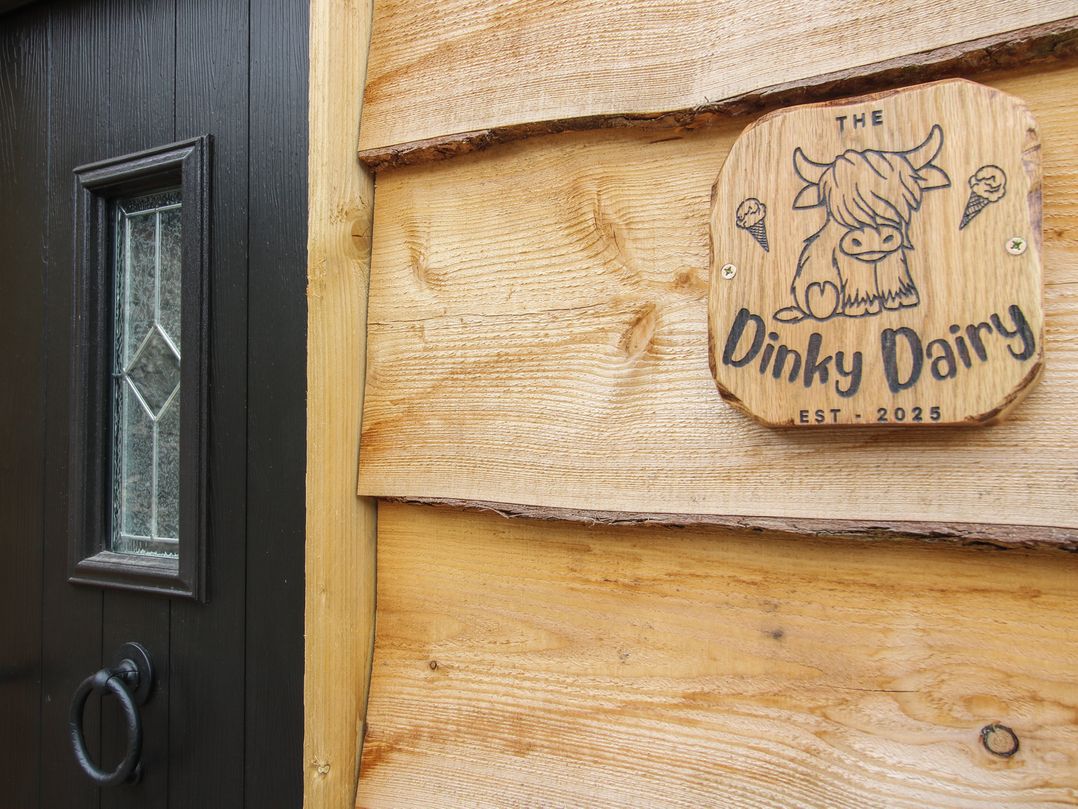 A door with a wooden sign at The Dinky Dairy in Treflach near Trefonen