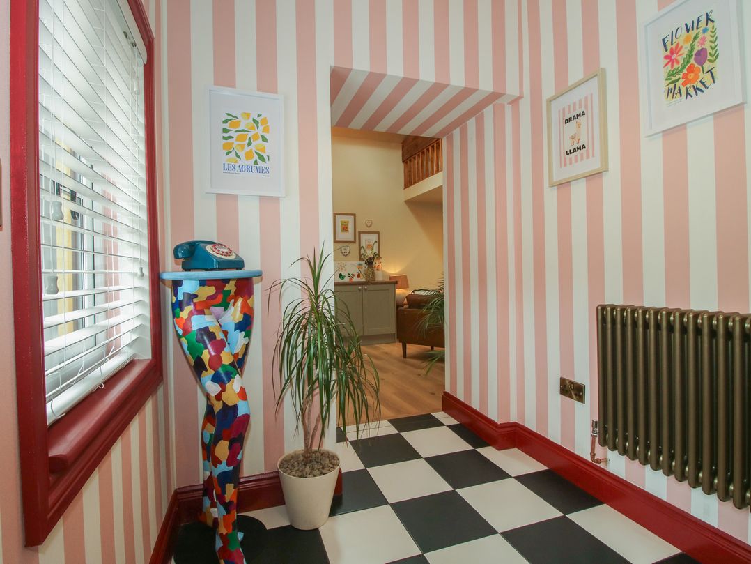 A hallway with colorful decor and a phone stand at The Dinky Dairy in Treflach near Trefonen