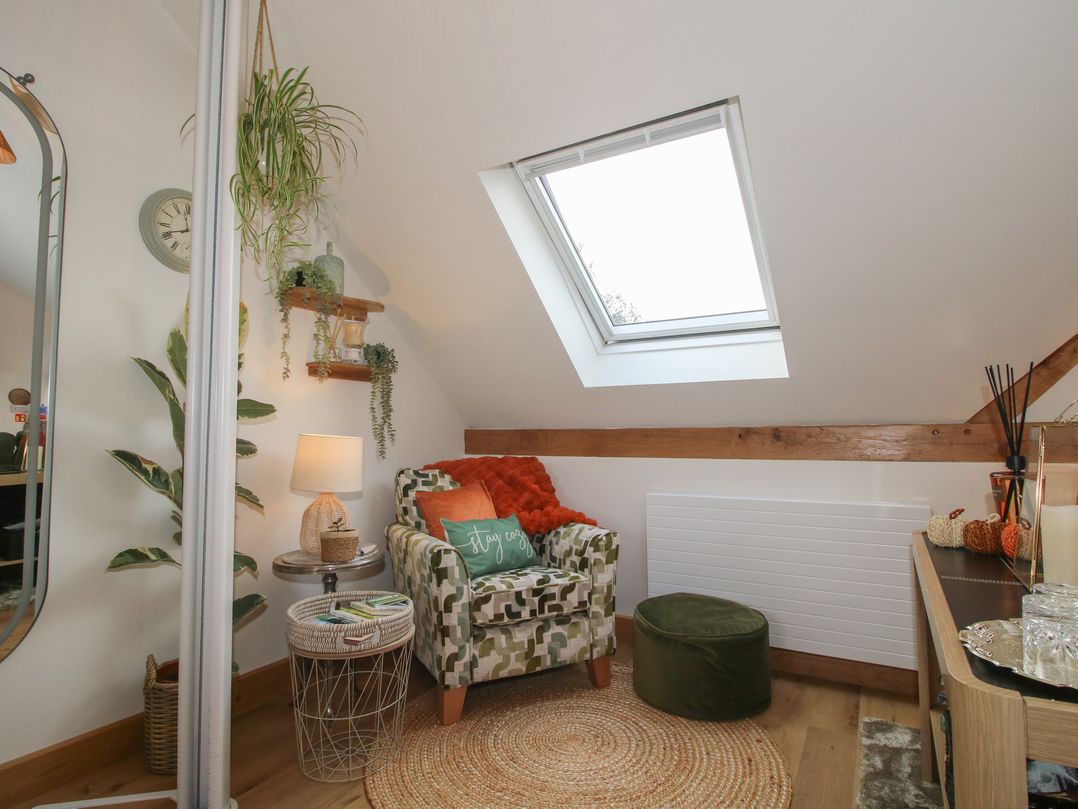 A snug with an armchair and lamp at Little Acre in Leominster