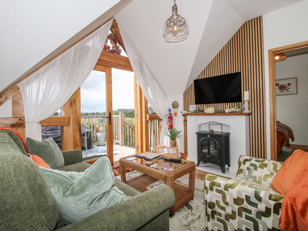A living room with seating, television, and balcony at Little Acre Leominster