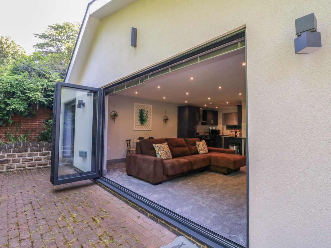 A living room with a sofa and kitchen view at Elmcroft in Nottingham