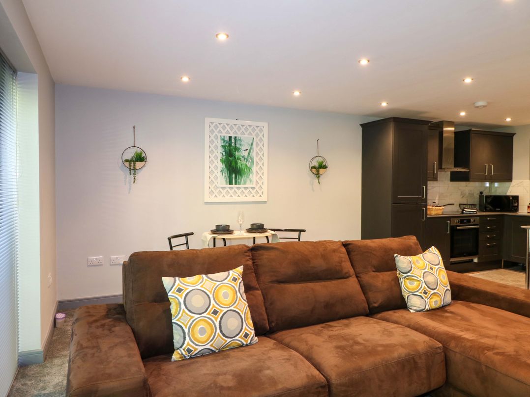 A living room with a sofa and dining area at Elmcroft in Nottingham