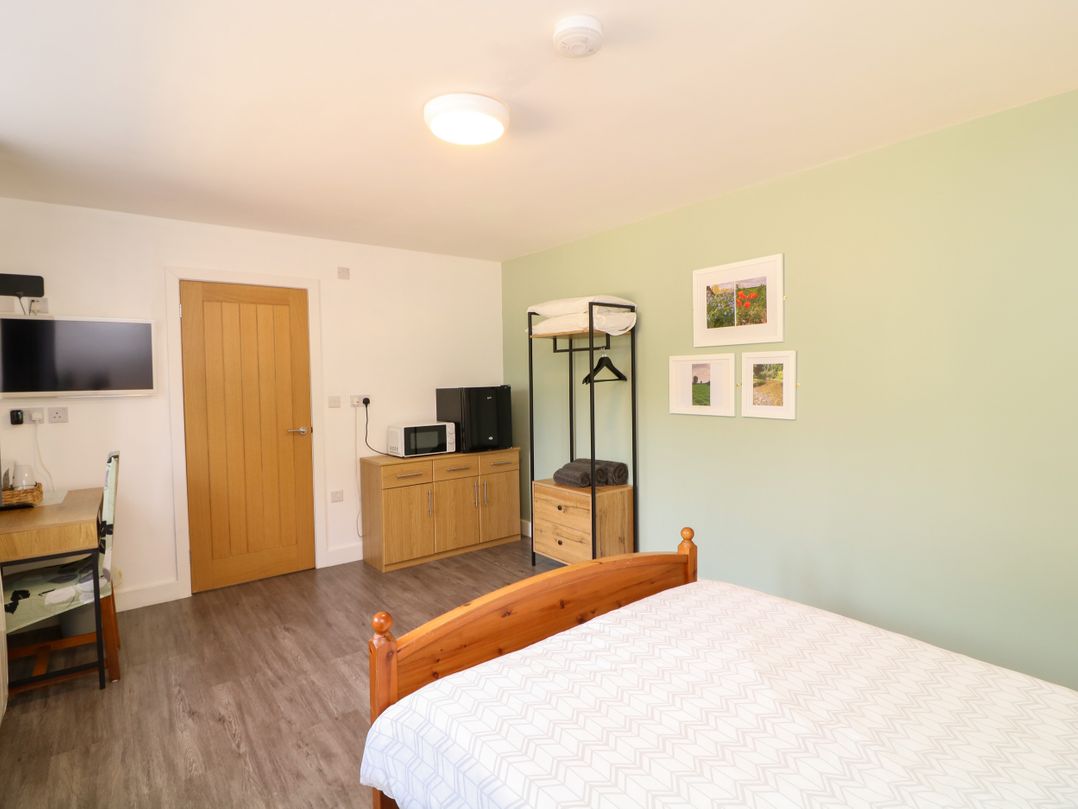 A bedroom with a bed and a table at Walcott Lodges - Catley, Billinghay, Lincolnshire