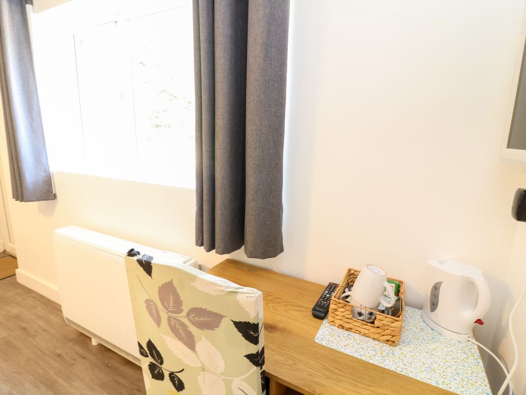 A study area with a window and a table with a kettle and a basket at Walcott Lodges - Catley, Billinghay, Lincolnshire