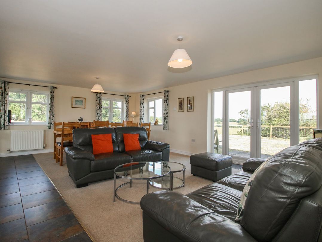 A living room with a sofa and dining area at Wood Cottage in Tenbury Wells